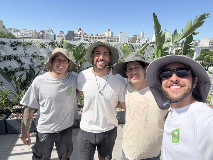 Leandro Vieyra junto a tres integrantes del equipo de Paisajismo Cuántico después de una jornada de trabajo en una terraza