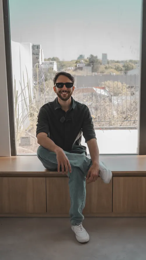 Leandro sentado en una obra terminada, con la ciudad de fondo