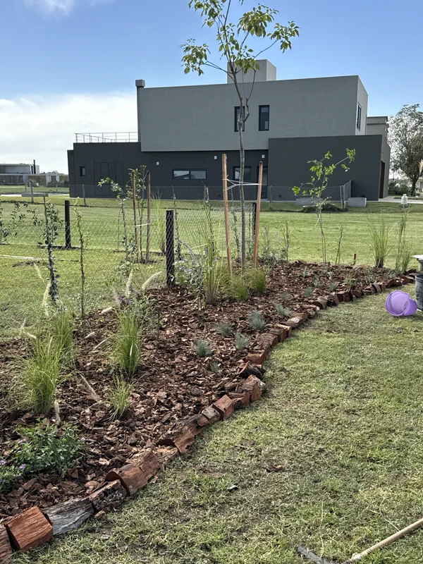 Vista amplia del jardín joven abierto hacia la laguna del barrio