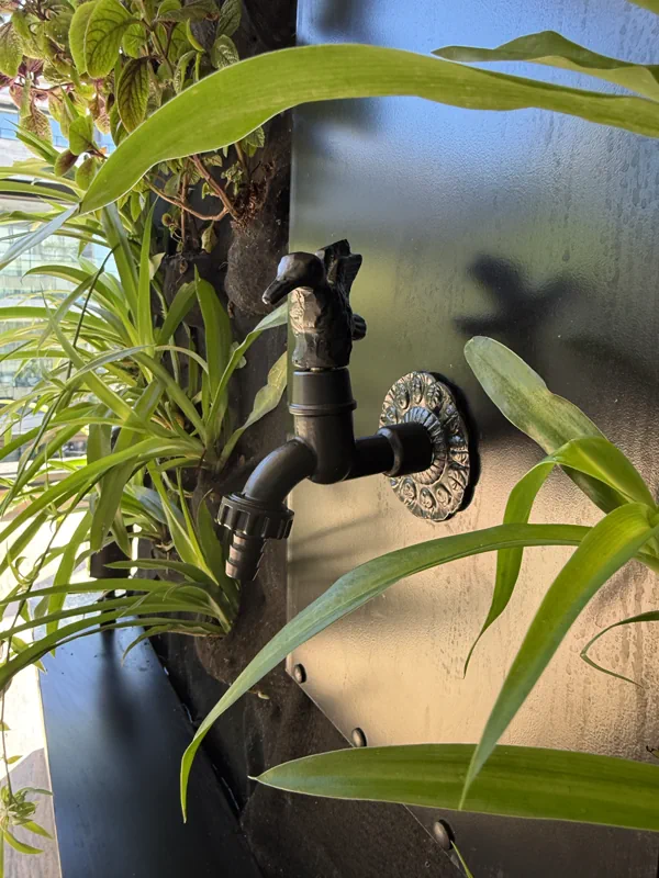 Canilla decorativa integrada entre las plantas del balcón